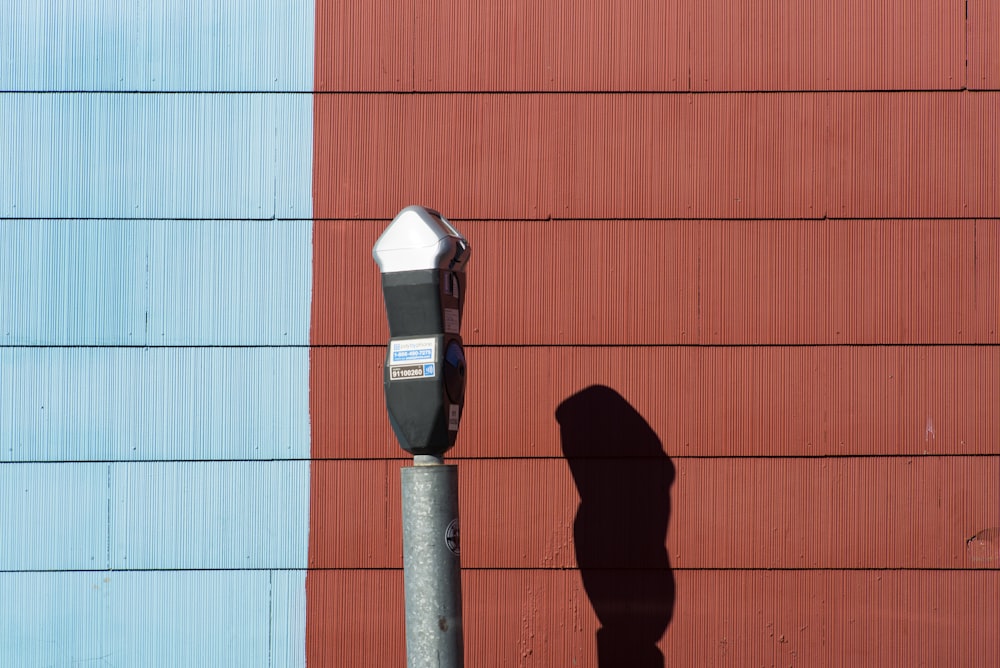 park meter beside wall