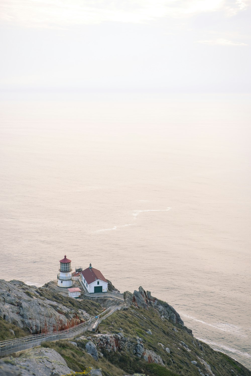 white and brown house on top of mountain near body of water during daytime