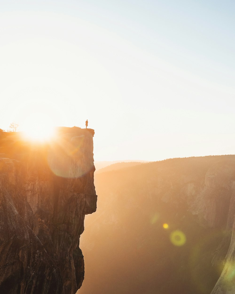 person standing on cliff during daytime