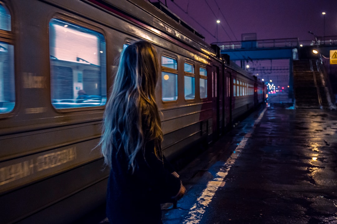 woman standing beside gray train