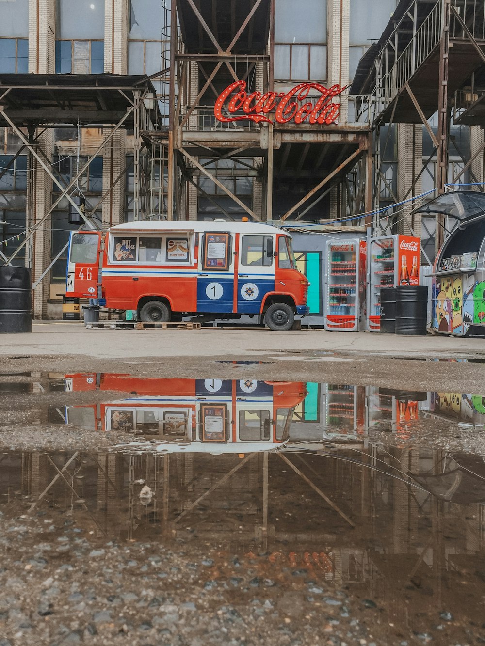 red and blue vehicle next to Coca-Cola storefront