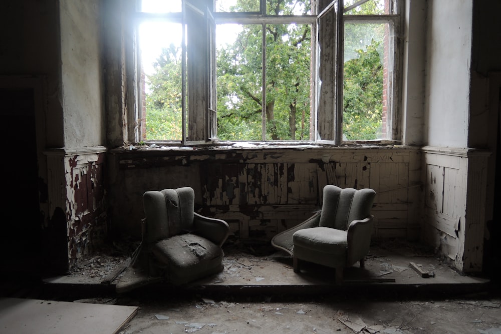 duas cadeiras de sofá cinza dentro da sala destruída
