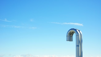 Close-up of a clean, shiny dryer vent pipe after service, with sunlight highlighting the metal surface.