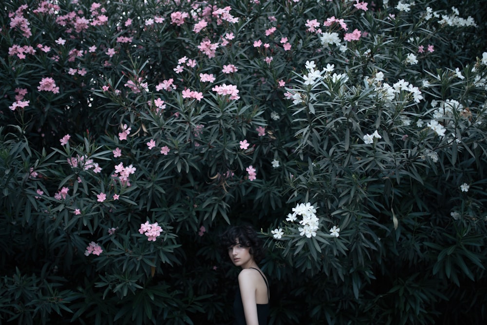 woman looking backwards while walking towards trees