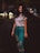 woman in white crew-neck T-shirt and distressed teal jeans waving hair