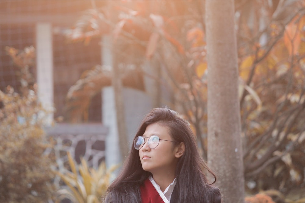 woman wearing black and red top and black framed eyeglasses at daytime