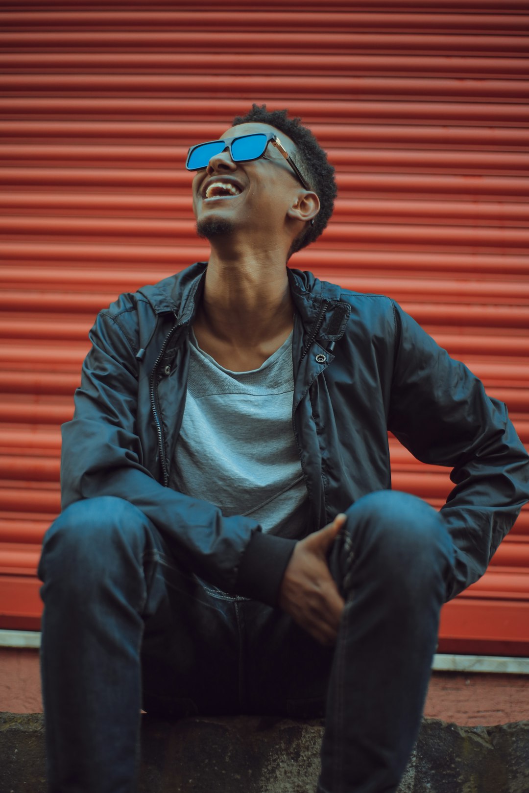 smiling man sitting on concrete floor