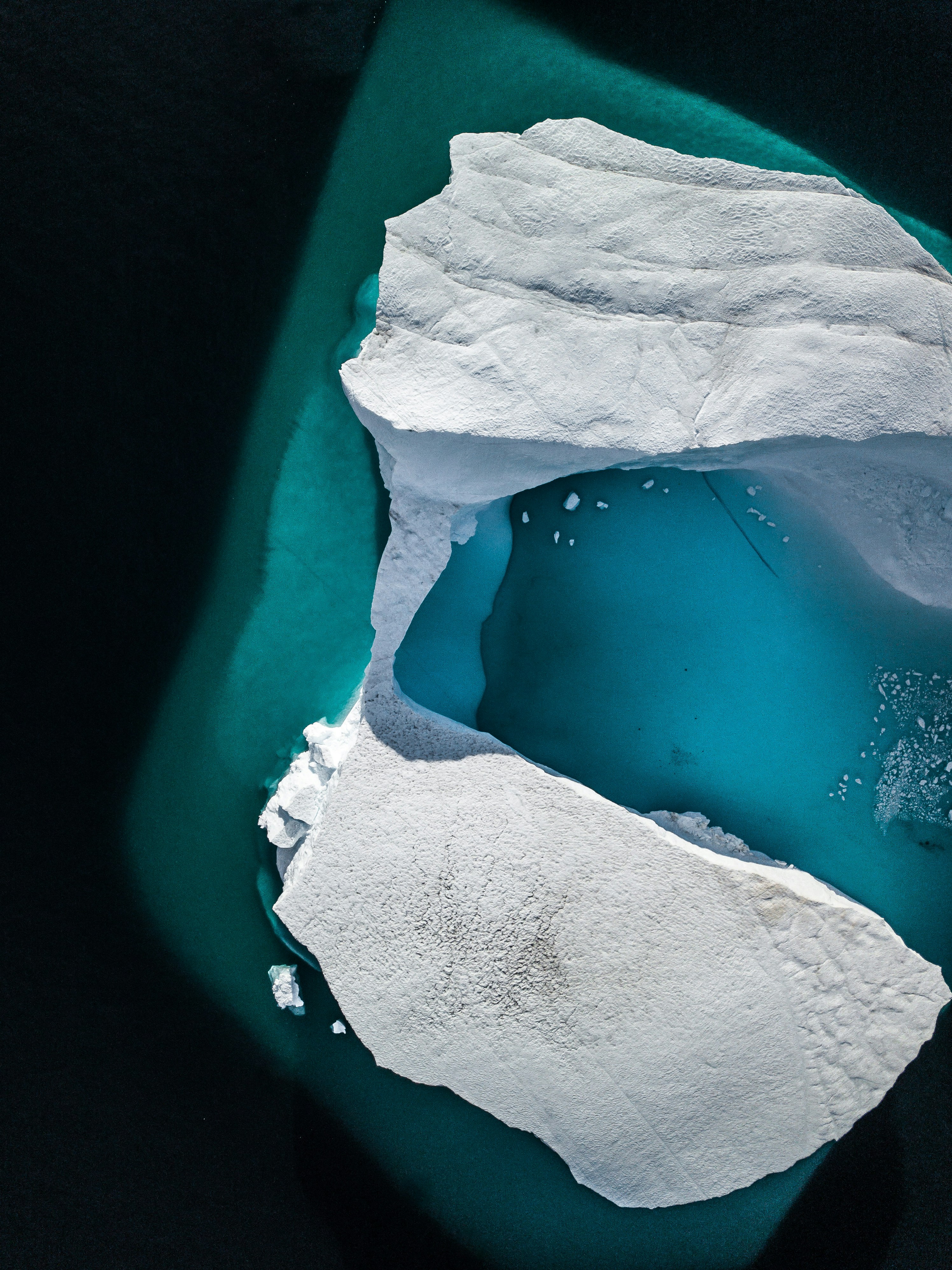 an aerial view of an iceberg in the water
