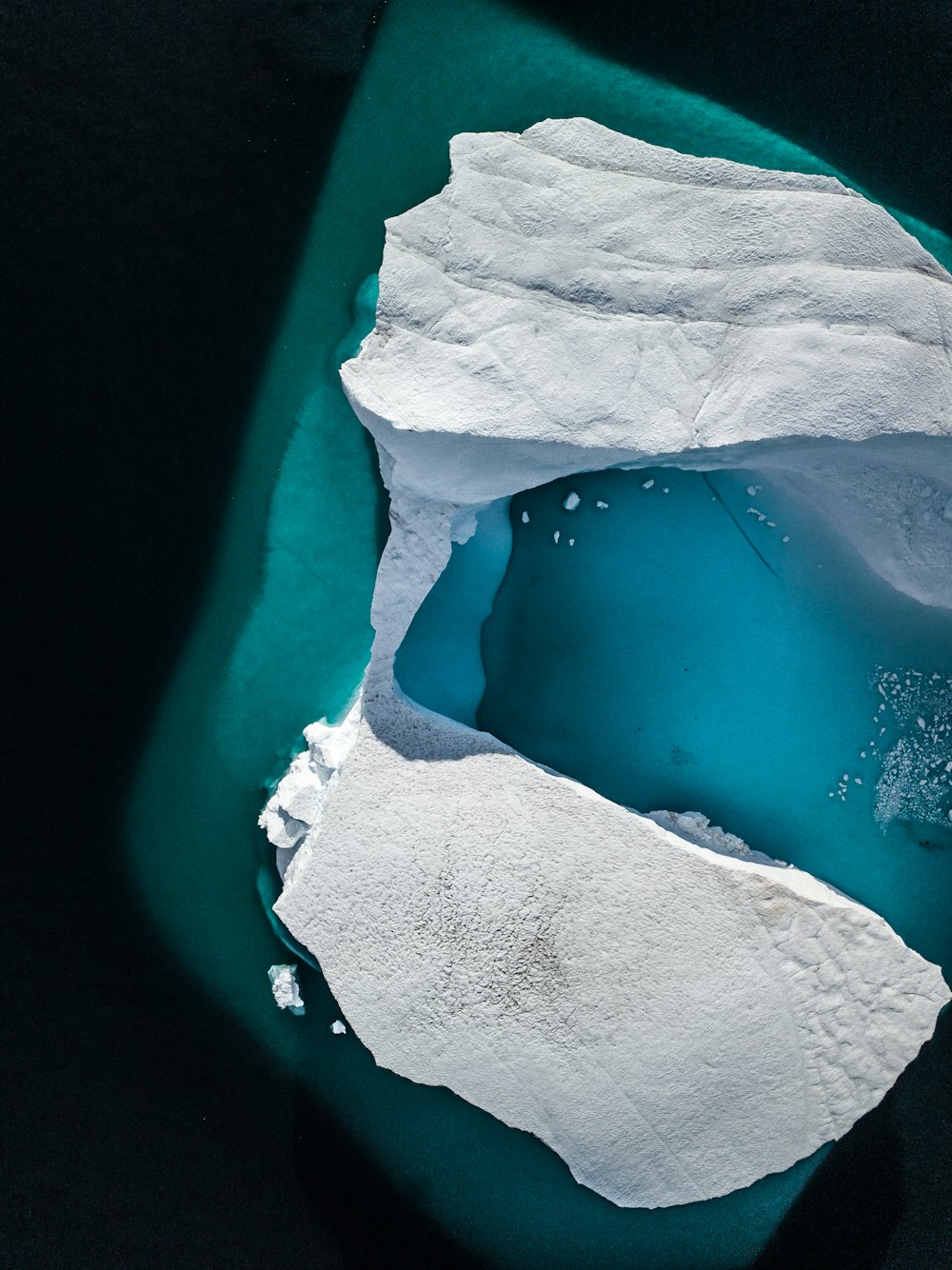 an aerial view of an iceberg in the water