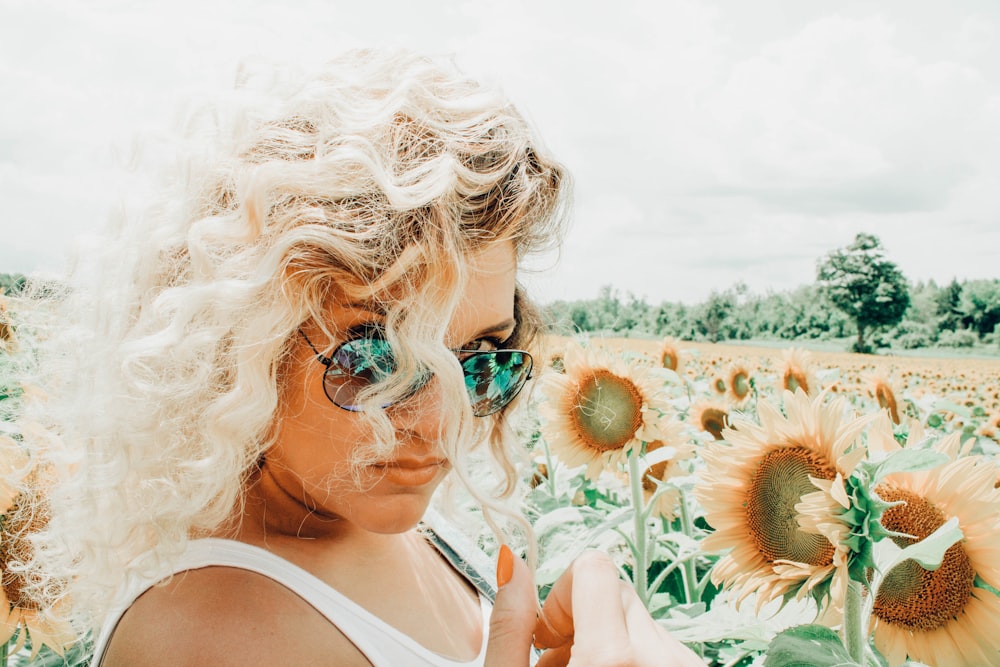 Mujer de pie en el campo de girasoles