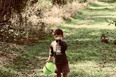 Children exploring nature with magnifying glasses in the outdoor play area.