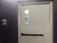 Close-up of a sturdy fire door installed in a modern building hallway.