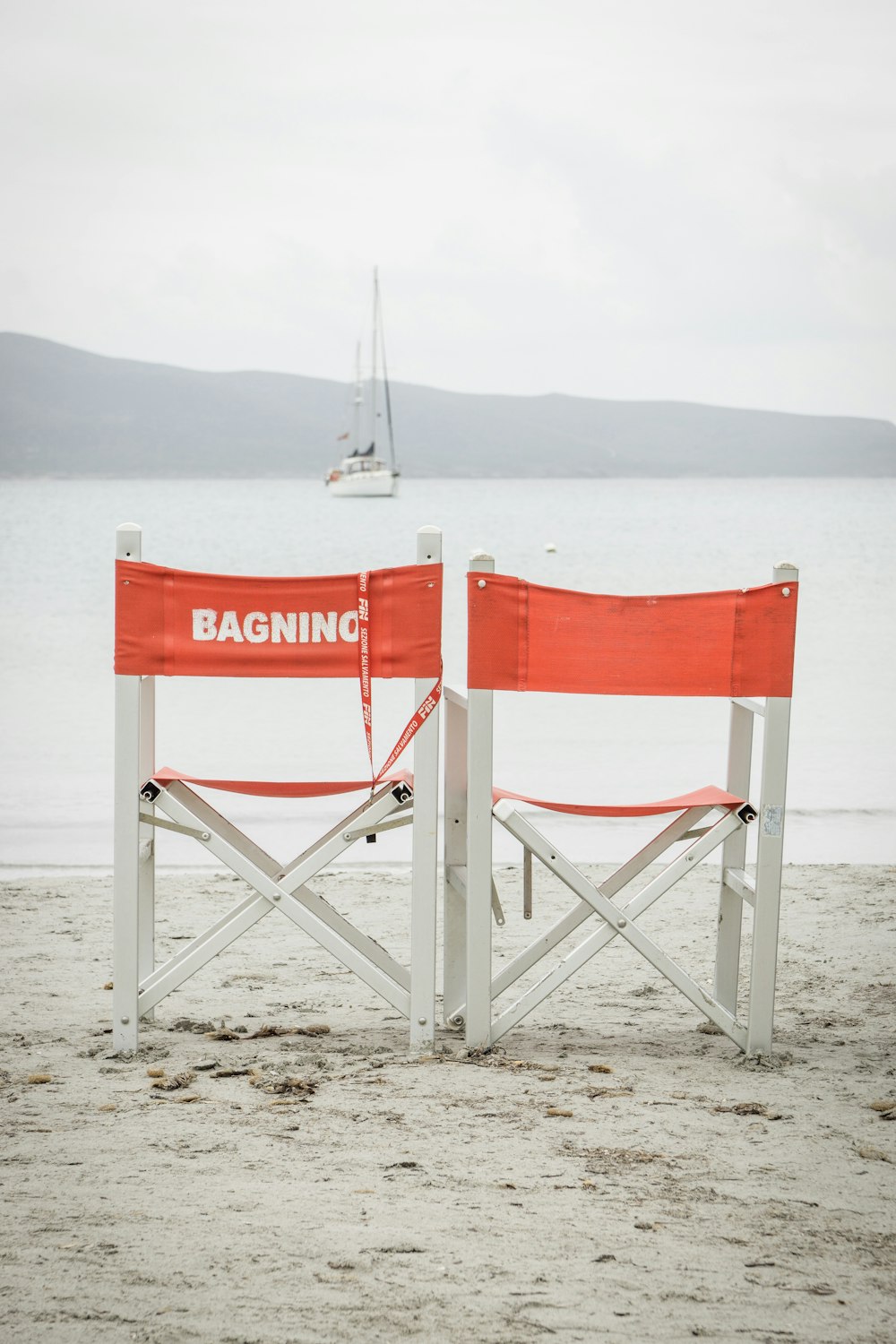 two white folding chairs during daytime at beach