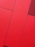 a close up of a red wall with metal rivets
