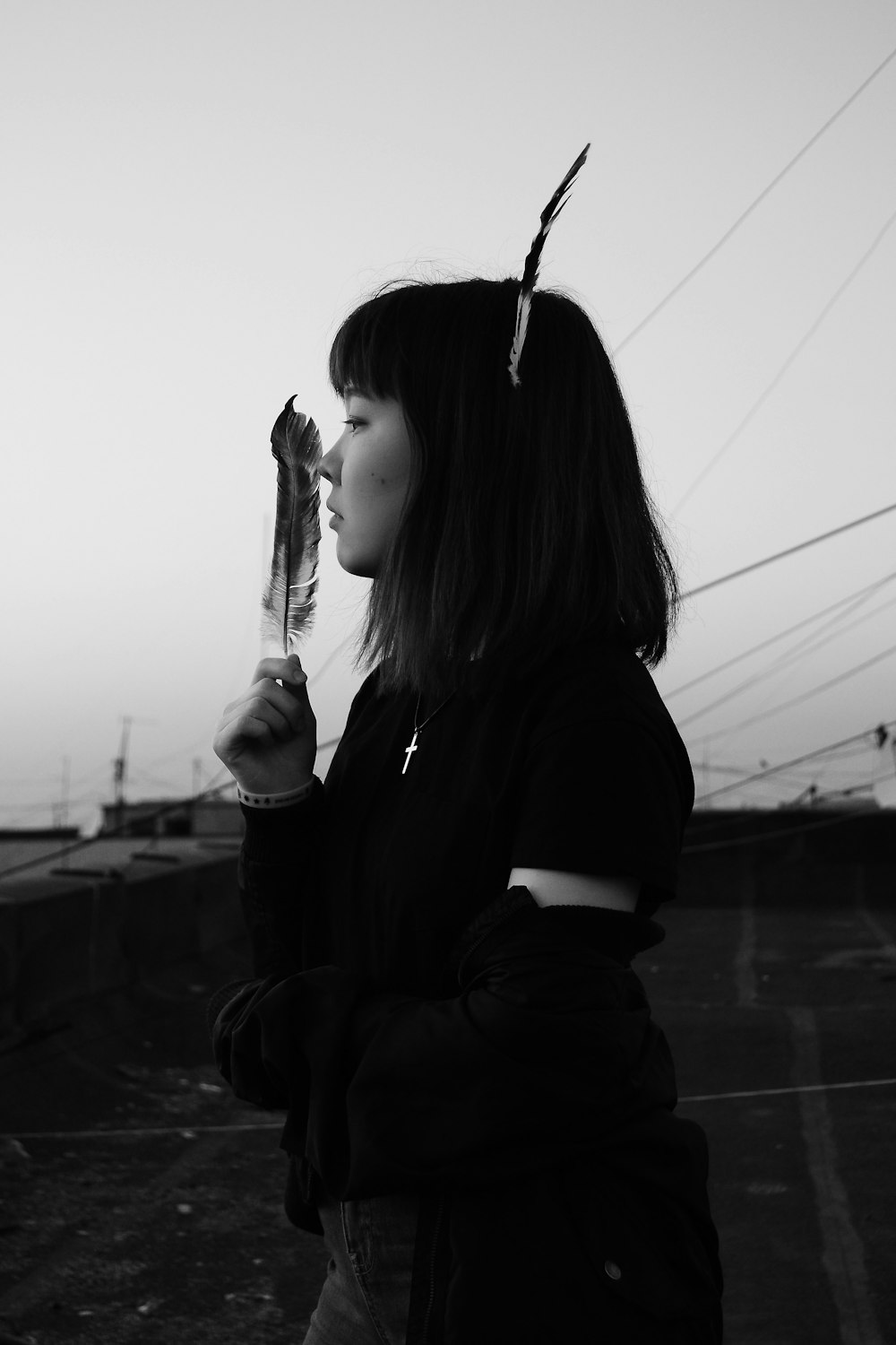 grayscale photography of woman holding feather