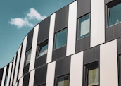 Wide shot of a modern building with sleek black and white facade panels reflecting premium craftsmanship.