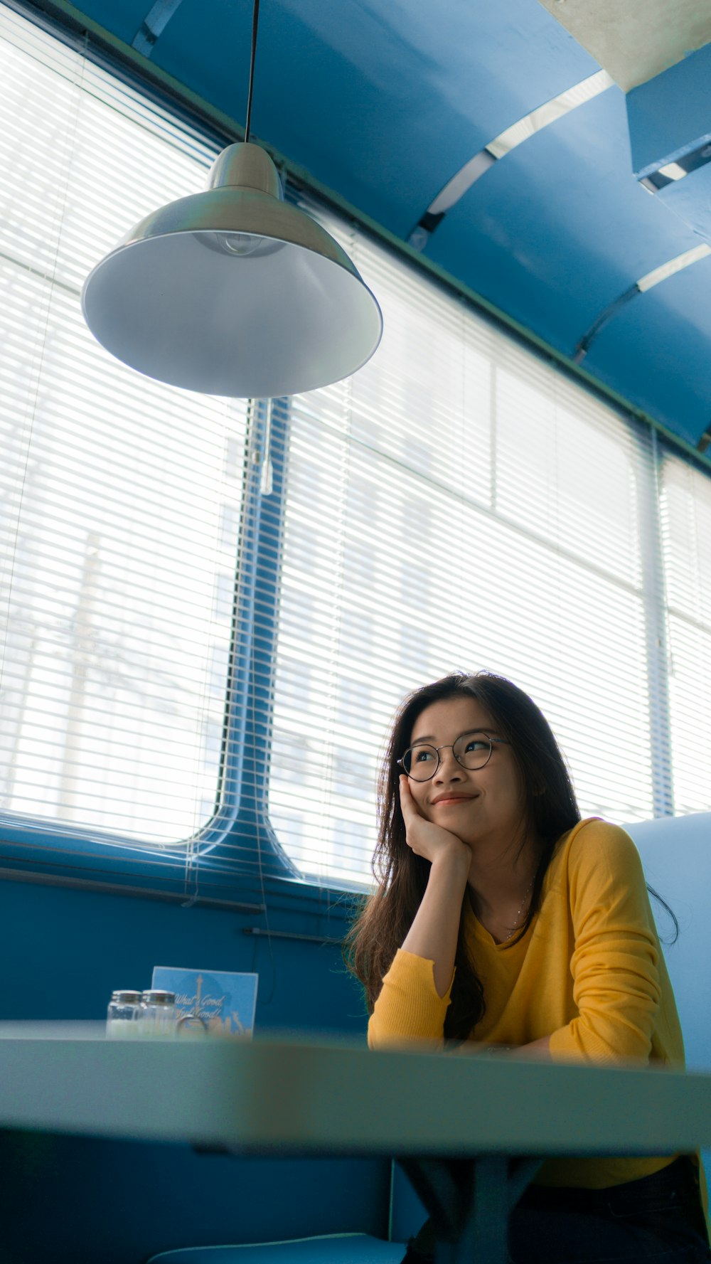 woman resting her chin on her palm while sitting on chair