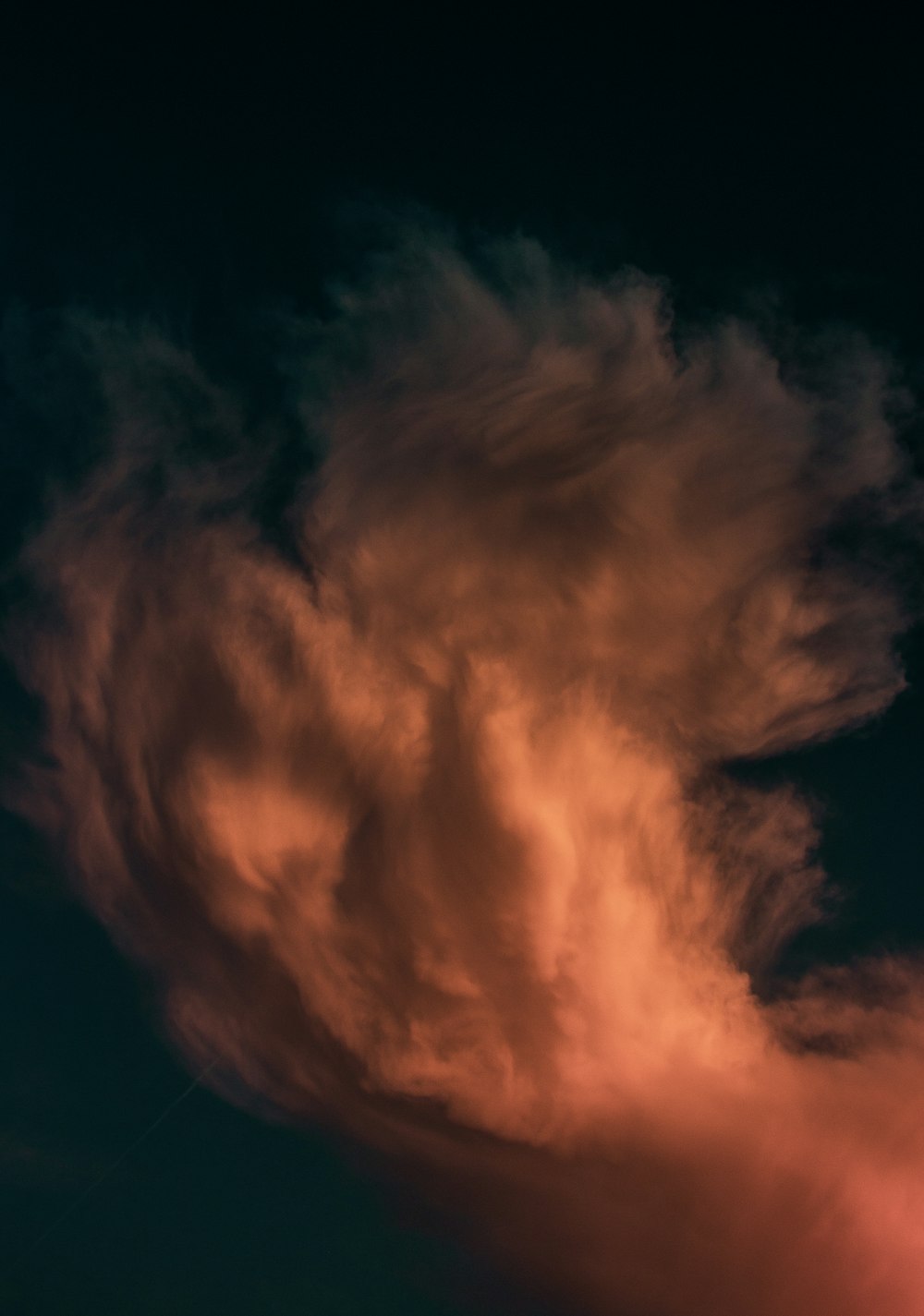 a plane flying through a cloudy sky at night