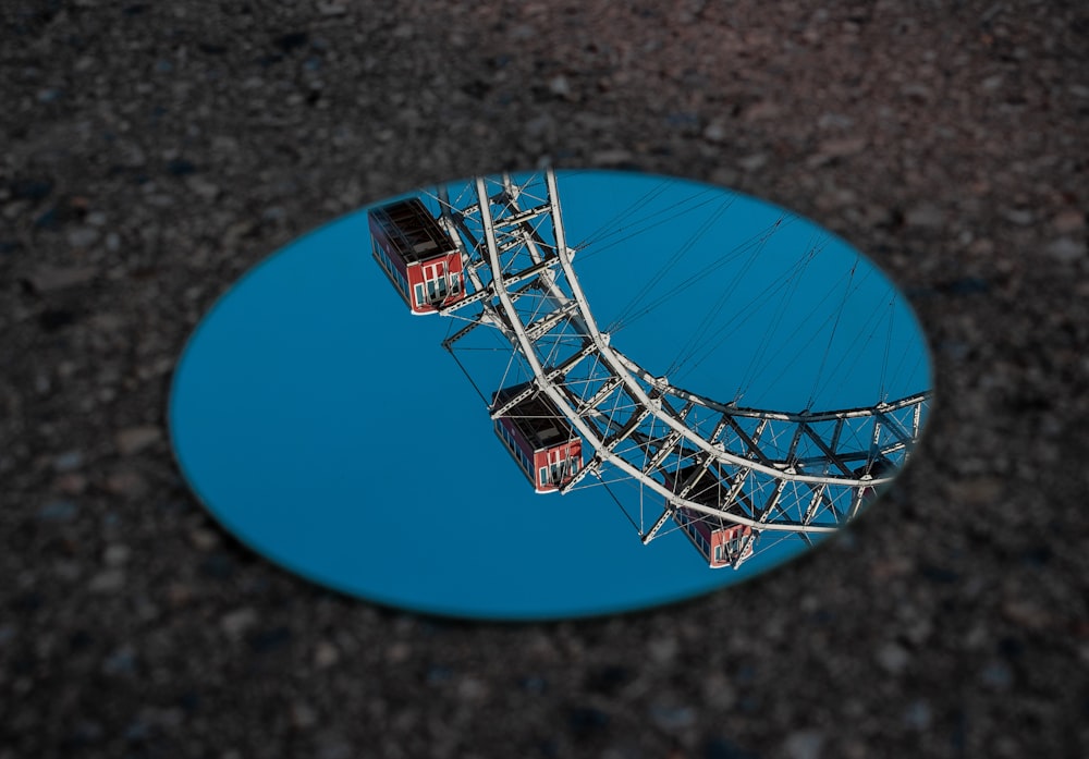 round mirror reflecting ferris wheel