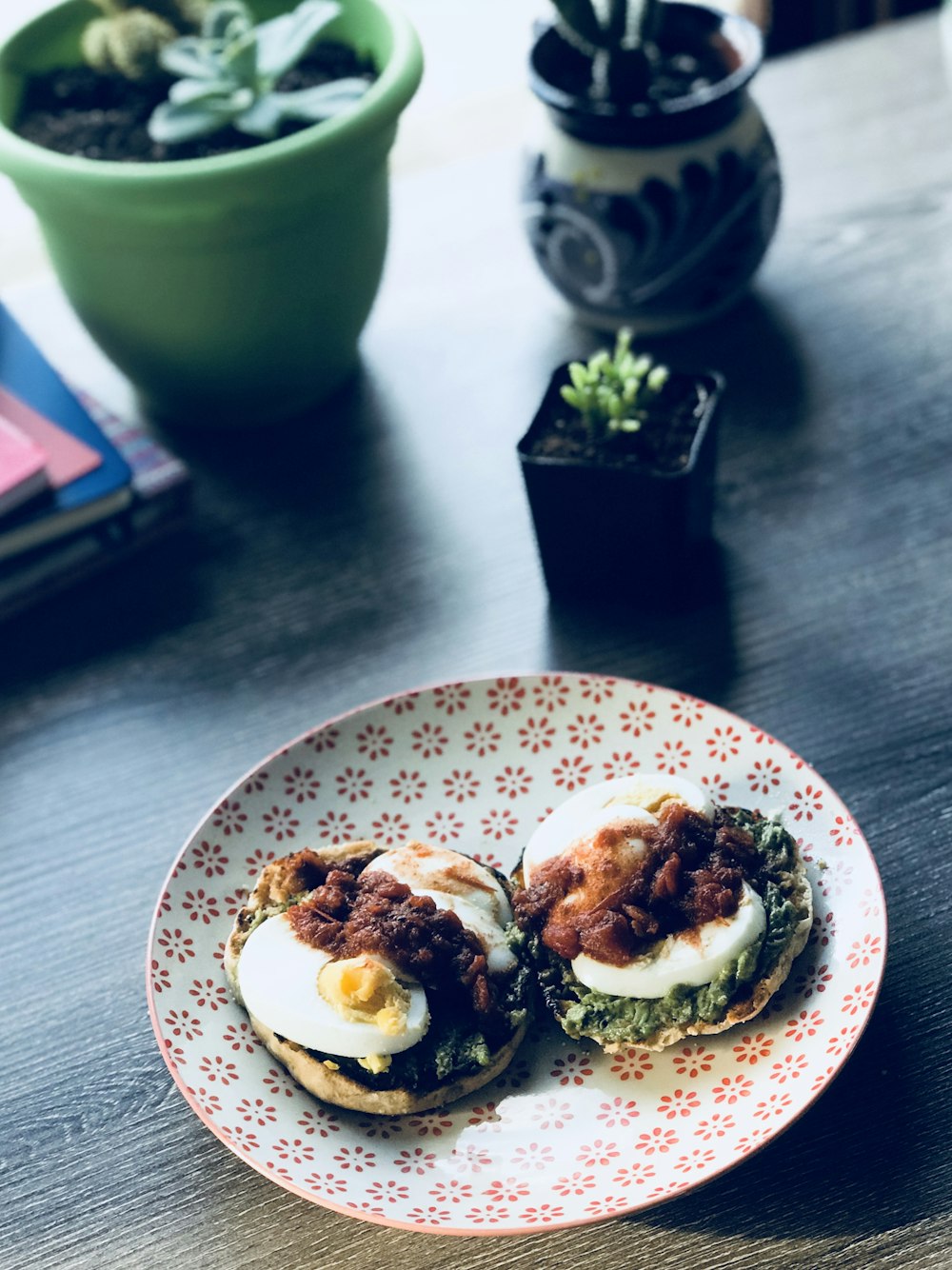 bread topped with egg and vegetable on plate beside plants