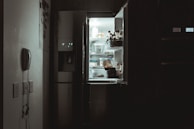 Technician inspecting the inside of a refrigerator during repair.