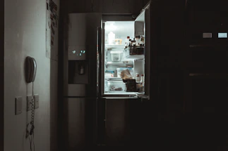Technician fixing a refrigerator in a cozy kitchen setting