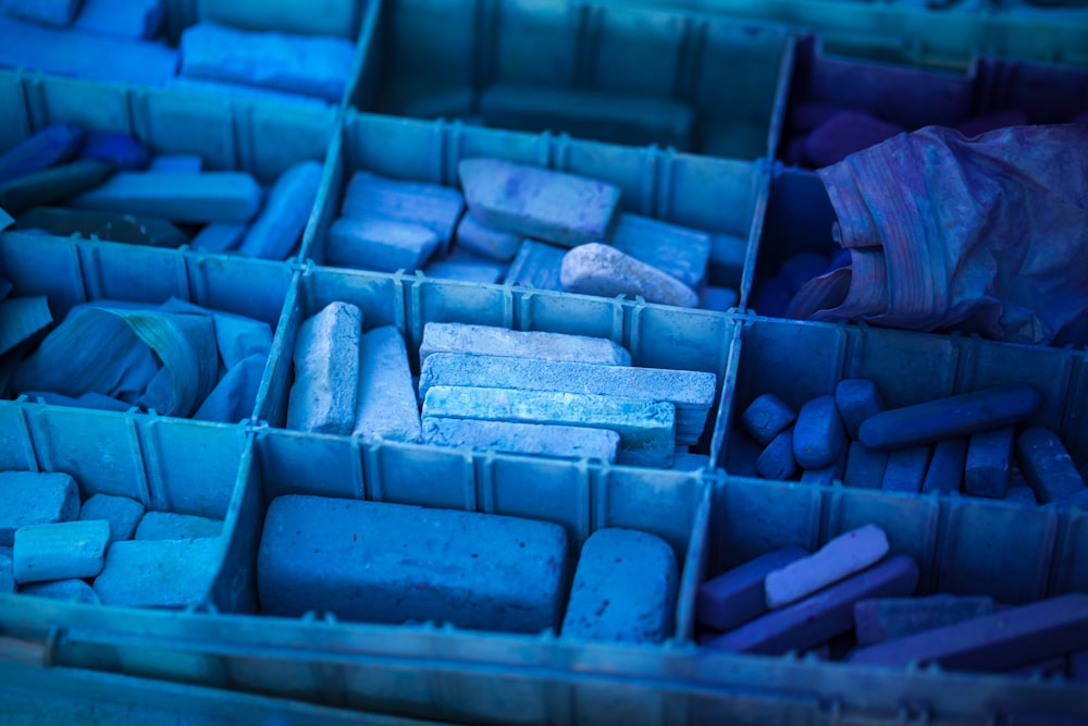 Una scatola blu piena di molte rocce colorate