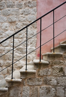 Rustic wooden stair guardrail blending with natural stone walls