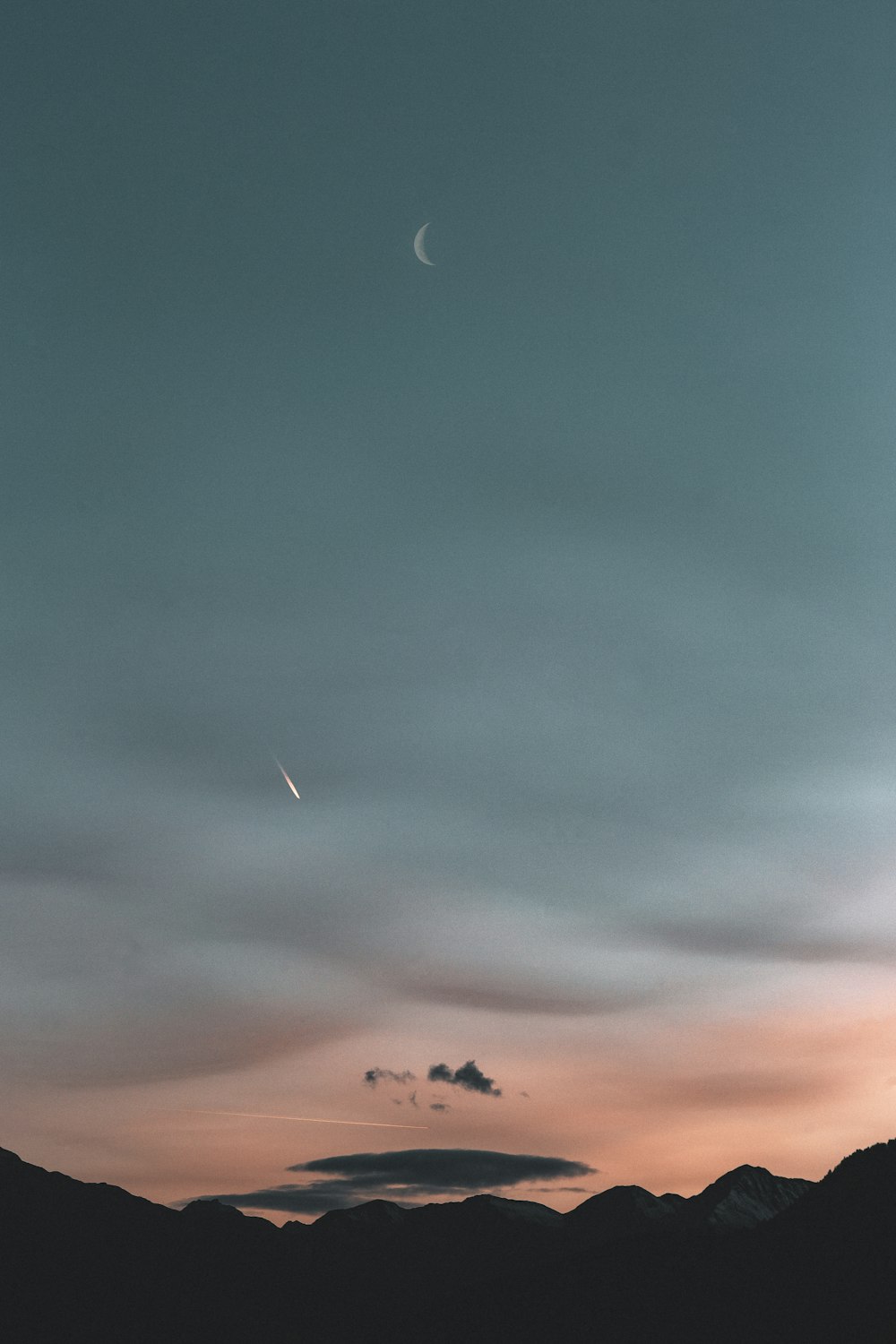淡い夕暮れの空に浮かぶ山のシルエット