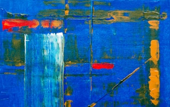 An abstract painting featuring a vibrant blue background with dynamic strokes of orange and red. Vertical and horizontal lines intersect across the canvas, adding structure and depth. A splash of white creates a focal point, contrasted by the bold colors around it.