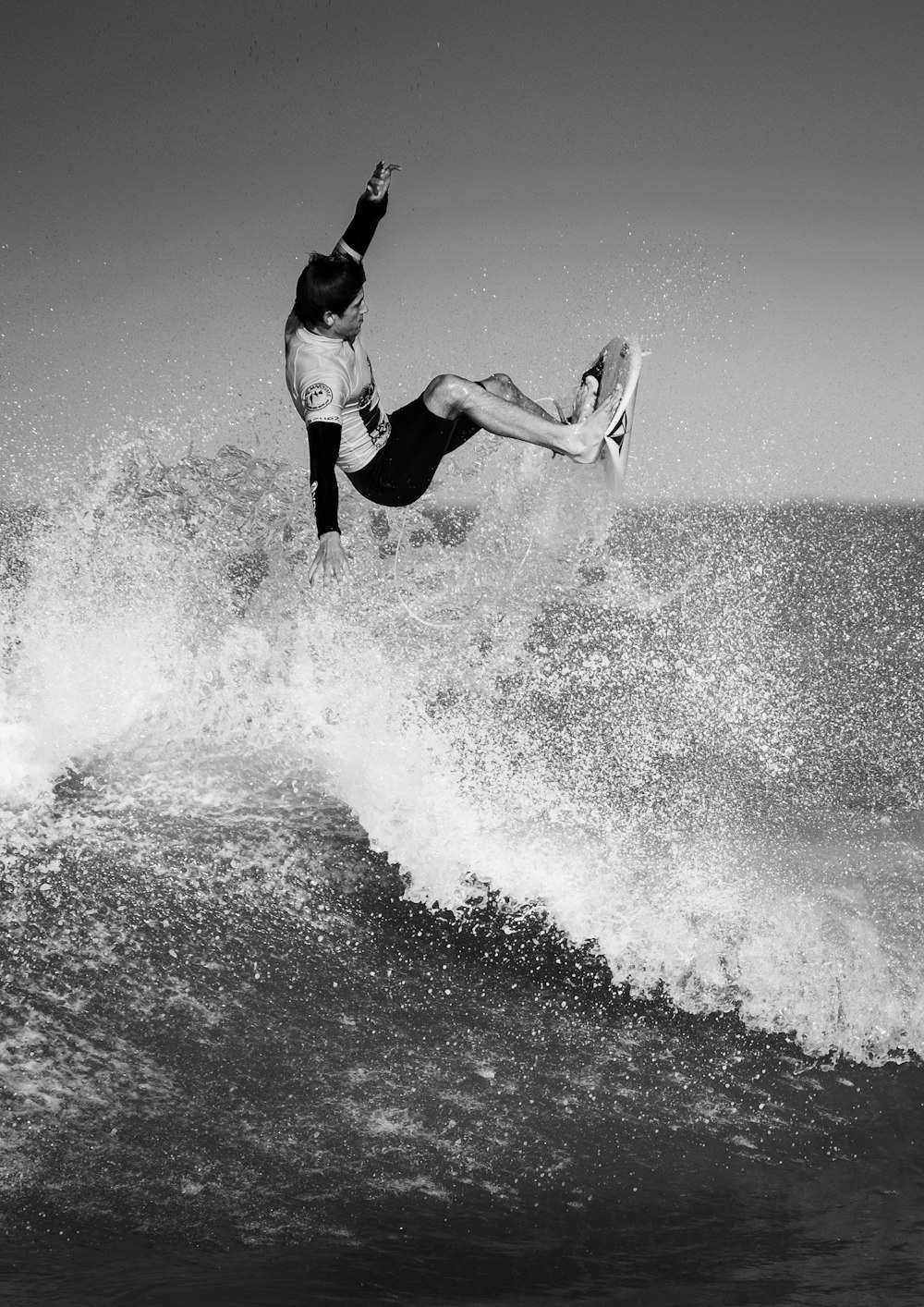 black and white photo of man surfing