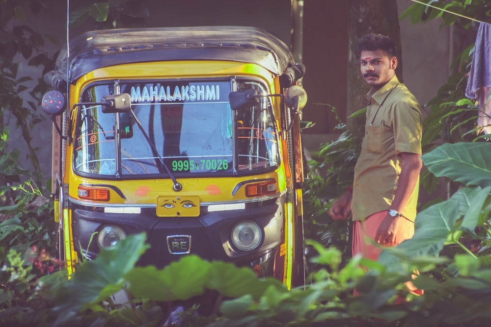 man standing beside of auto-rickshaw