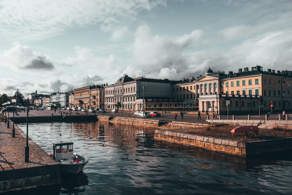 white and black boat on river near buildings during daytime