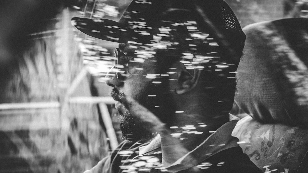 Photo en niveaux de gris d’un homme à l’intérieur d’un véhicule