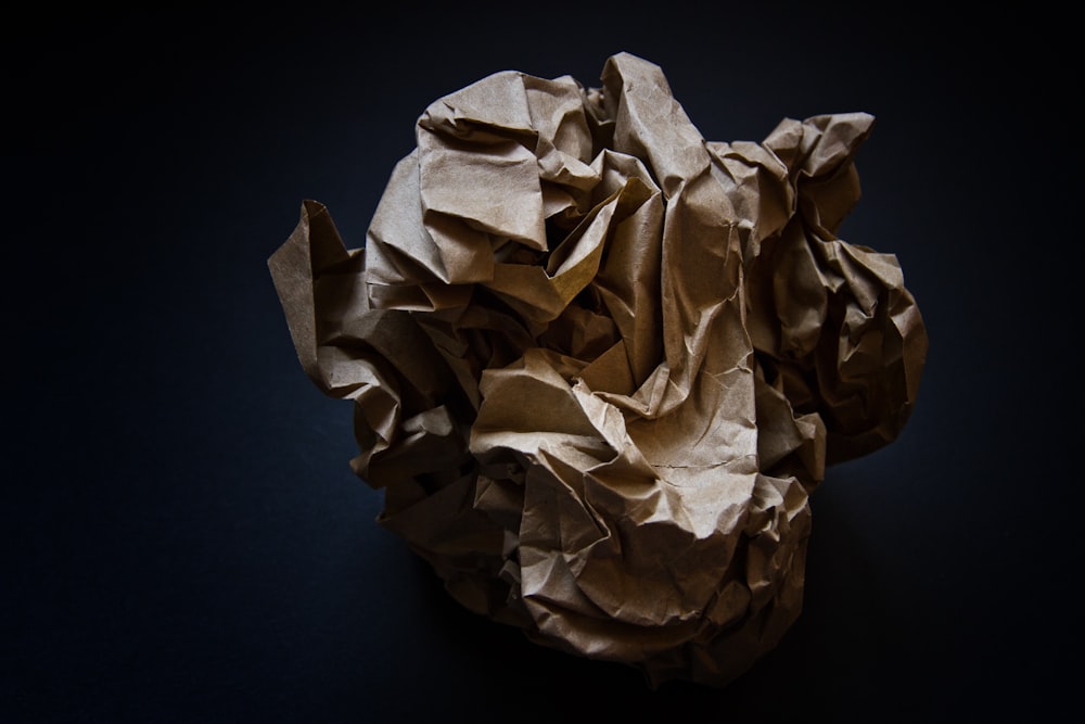 a crumpled paper ball on a black background