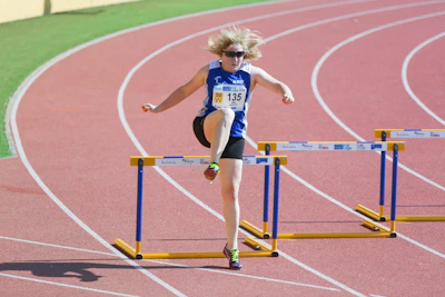 A focused teenager preparing to launch into a triple jump with determination.