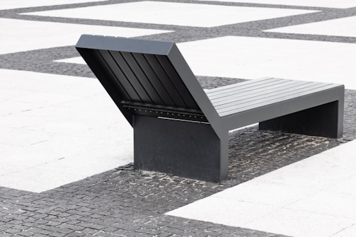 Modern concrete bench placed in a minimalist garden setting.