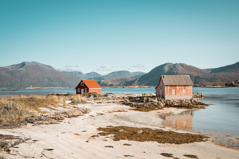 two houses beside body of water under clear blue sky during daytime