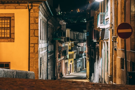 shallow focus photography of stop sign between concrete buildings in Amarante Portugal