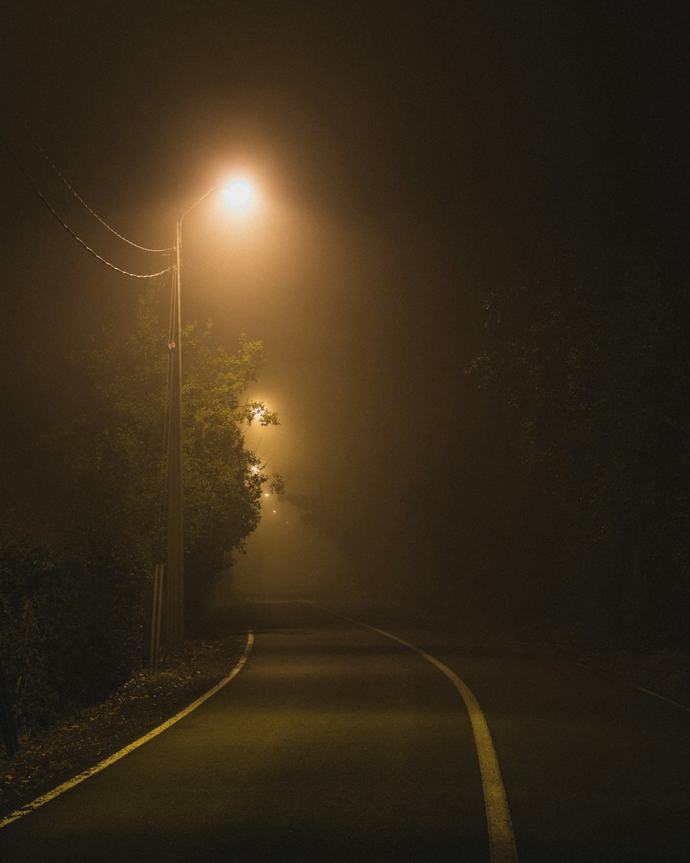 Poste da Rua Laranja ligado ao lado da Estrada de Asfalto durante a noite