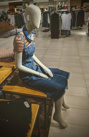 Mannequin dressed in a stylish casual outfit featuring a denim jacket and patterned blouse.