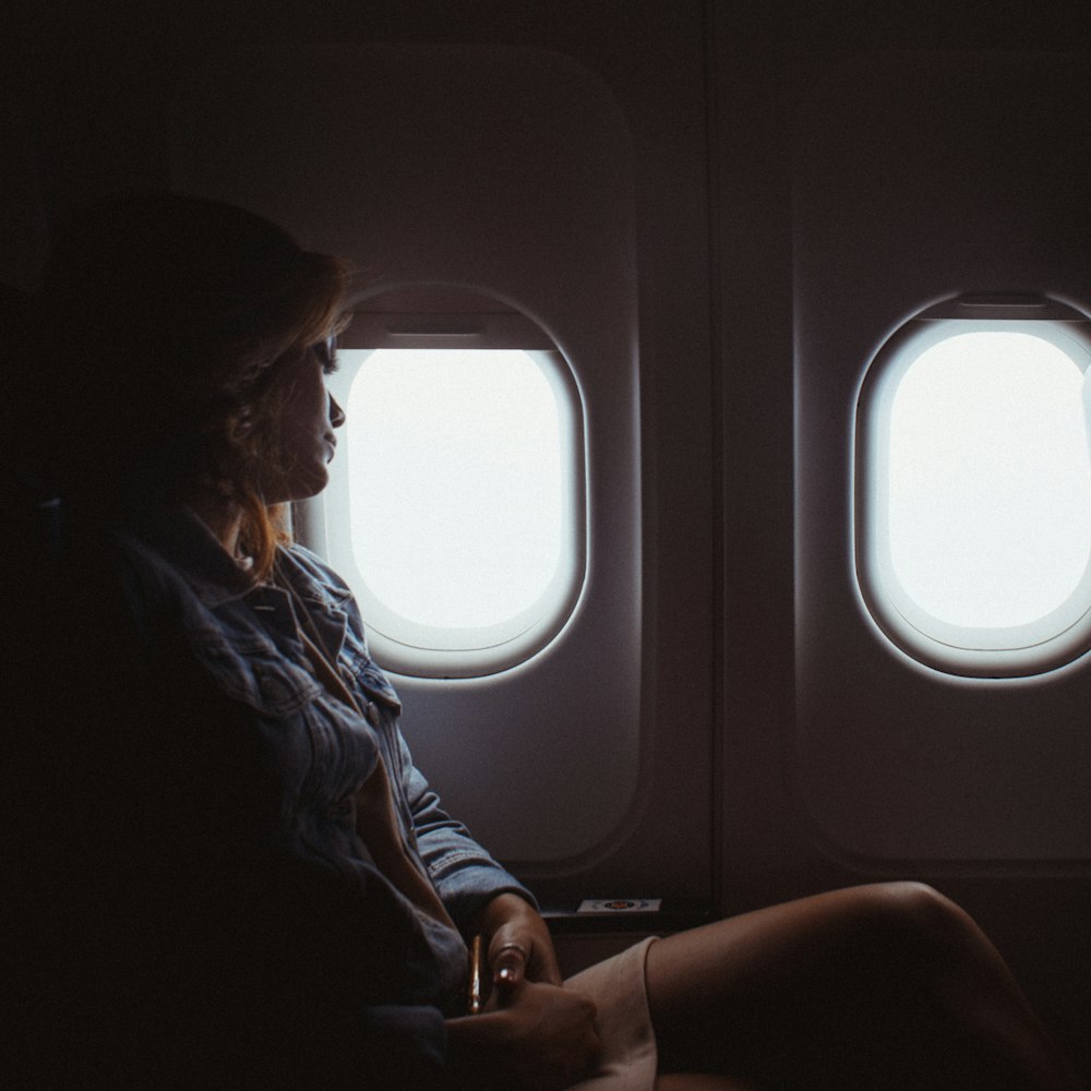 mulher sentada dentro do avião