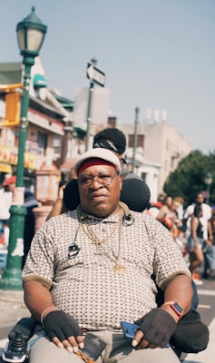 man sitting on motorized wheelchair on street at daytime