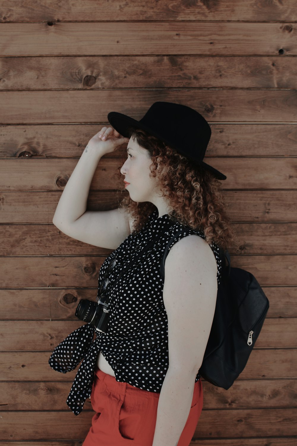 woman standing beside wooden plank looking sideward