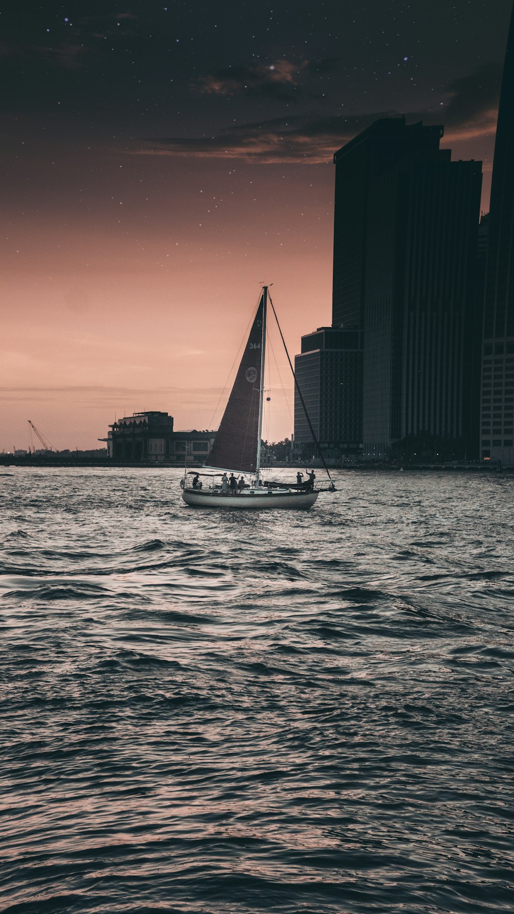 black and gray sailboat on body of water