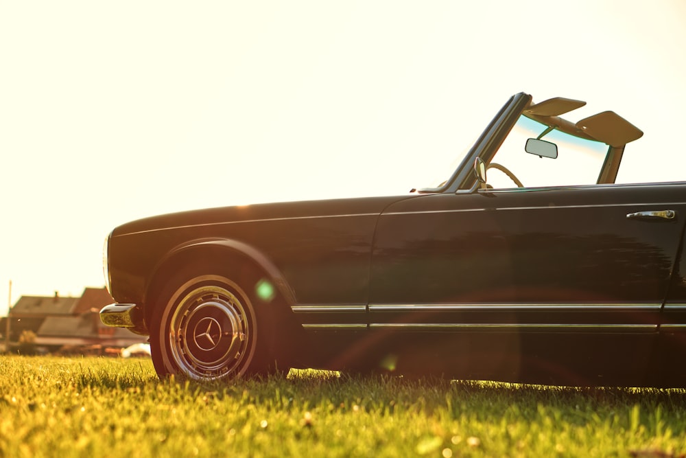 black Mercedes-Benz convertible car parked on grass field