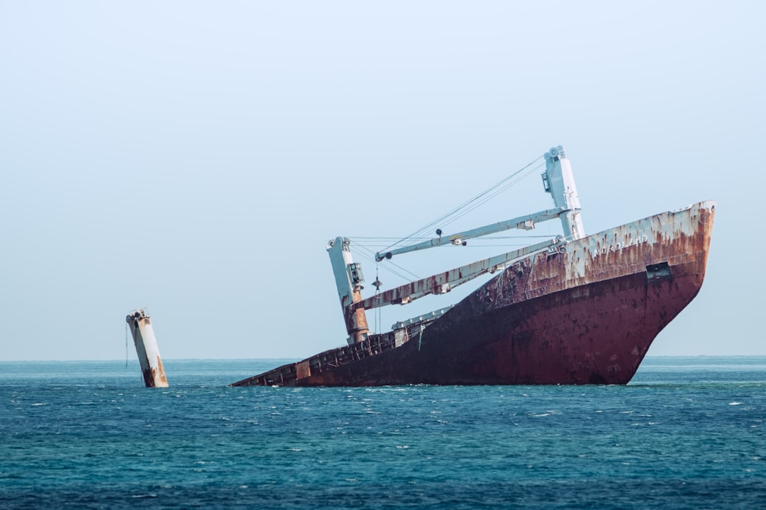 ship sinking on ocean at daytime,