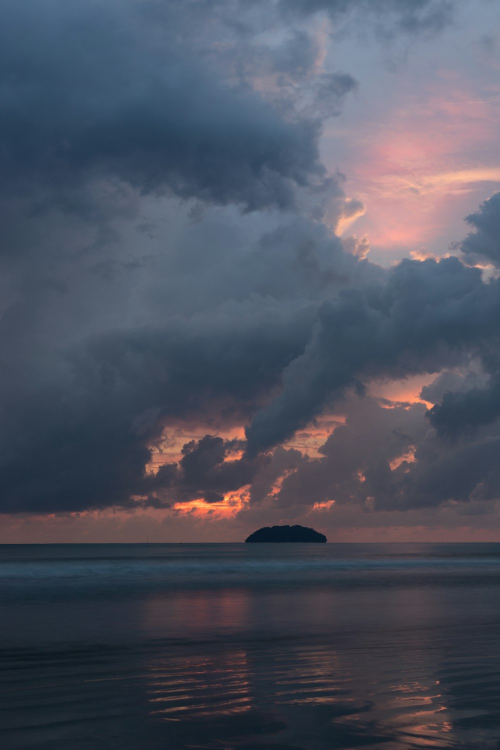 photo island under cloudy sky during golden hour