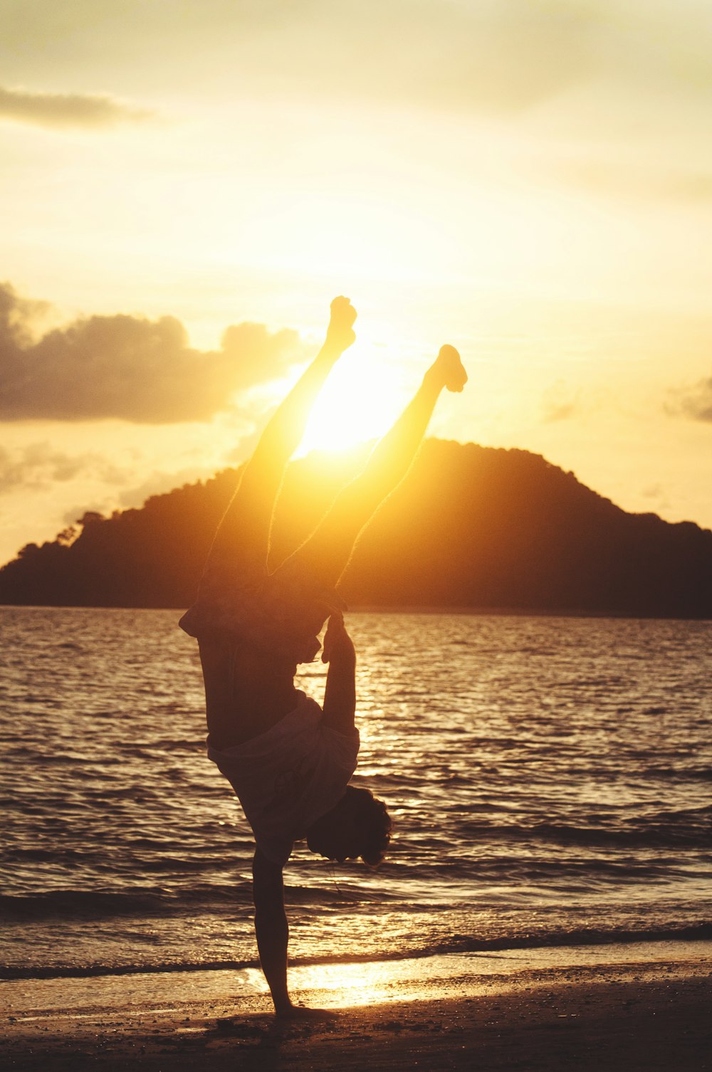 silhouette photo of man hand standing on seashore