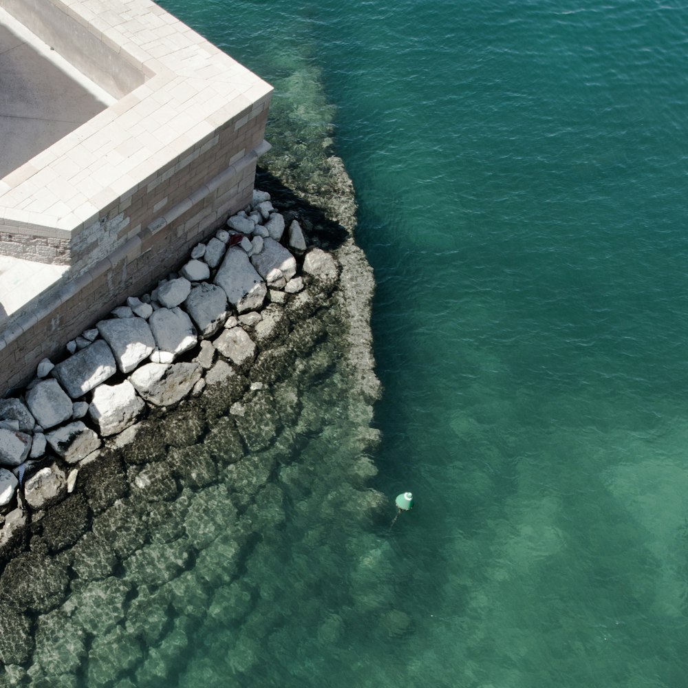 body of water beside gray concrete wall